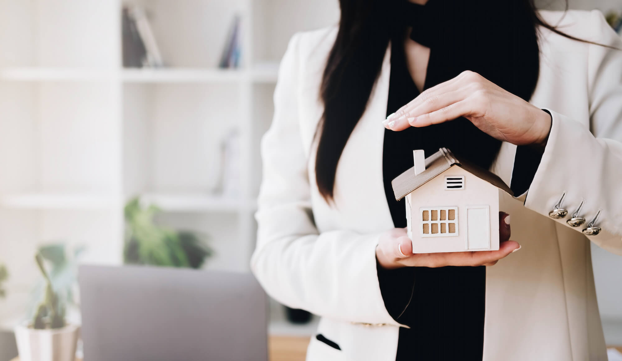 Close up of businessman holding model house